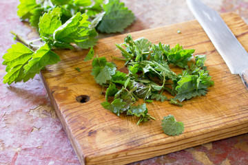 The crushed leaves brewed raw nettles on the kitchen table a rustic background.