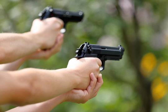 Young boys practice shooting guns on outdoor