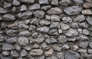 The wall made of gray stones and cement