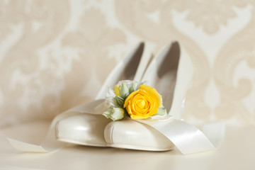 Bride`s wedding accessories: wedding shoes, rings and bouquet or boutonniere with yellow and white flowers 