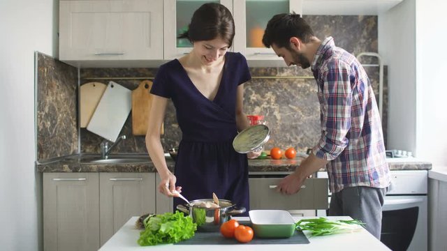 Happy young couple cooking in modern kitchen at home