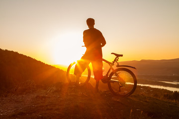 Fototapeta na wymiar Biker resting while watching sunset