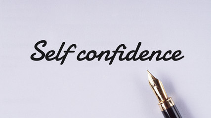 "Self confidence" words written on white paper using fountain pen - business and finance concept