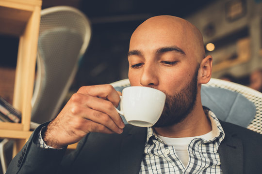 Close up portrait of man drinking coffee in cafe