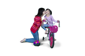 Mother and daughter with bicycle in studio