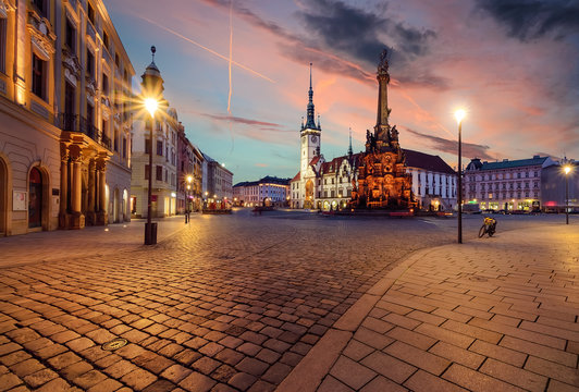 Town hall and Holy Trinity Column in Olomouc during sunset.