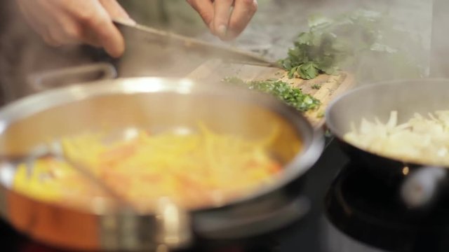 Close-up of two chef hands cooking food in restaurant kitchen