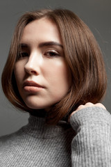 Naklejka premium Portrait of a young girl model with clear skin, looking at the camera.
