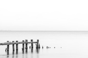 Seascape tranquil background with room for text, rustic pier posts in lower left of water