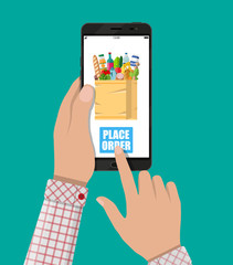 Hand and smartphone with shopping bag