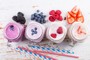 Selection of colorful detox berry drinks on wood background