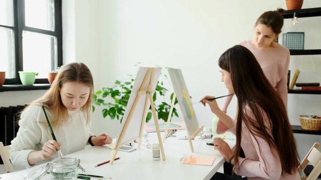 Group of students painting at art lessons 4k 20s