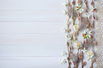 Easter light wood background with flowers daffodils, hyacinth, feathers, willow twigs