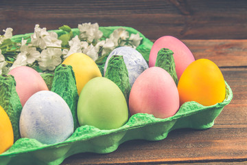 Easter colored chicken and quail eggs on a wooden background.