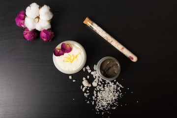 Cosmetics and flowers on a black background