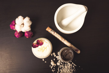 Cosmetics and flowers on a black background