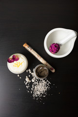 Cosmetics and flowers on a black background