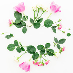 Round floral frame with beautiful roses, pink tulips and leaves on white background. Flat lay, top view. Floral background