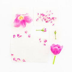 Paper cards with roses, petals and tulips on white background. Flat lay, top view. Vintage background