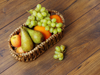 Fruit basket with grapes on a wooden table.