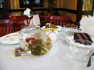 Teapot with tea and dessert on the table in the cafe photo