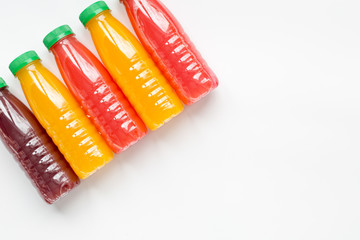 plastic bottles with fruit drinks on white background top view mock up