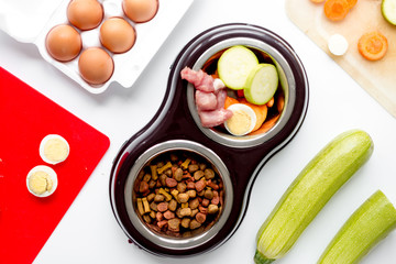 petfood set with vegetables and eggs on kitchen table background top view