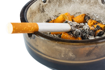 Close up of cigarette in ashtray on white background