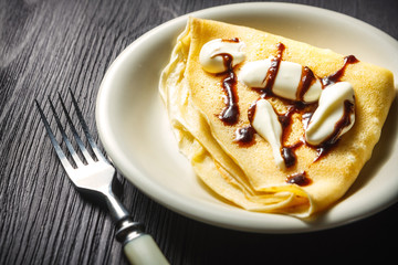 Crepe with whipped cream and chocolate sauce
