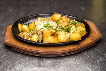 fried potatoes with meat in a frying pan