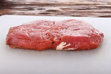 raw steak on a white board