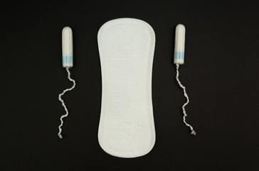 Women Sanitary pads and tampons on a black background.