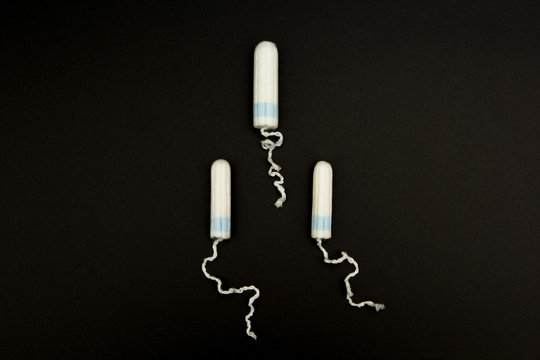 Three tampons on a black background.
