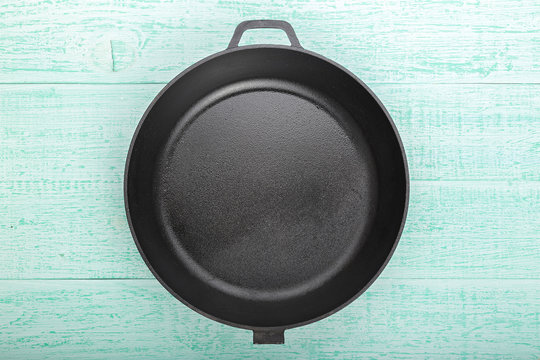a cast-iron frying pan on a wooden background