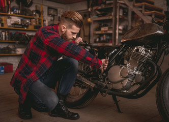 Obraz premium Guy in motorbike repair shop