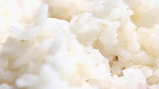 White rice on a platter rotates, macro view. 