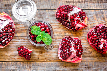 sliced pomegranate on wooden background top view