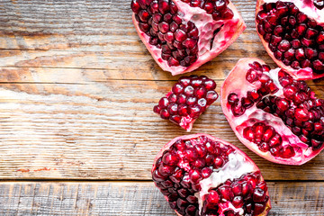 sliced pomegranate on wooden background top view