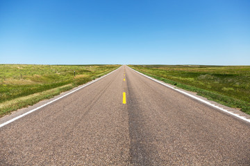 A road cutting through northern Nebraska on a summer day.