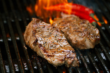 pork steak on bbq grill with flame