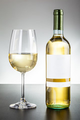 Shiny white wine glass and bottle