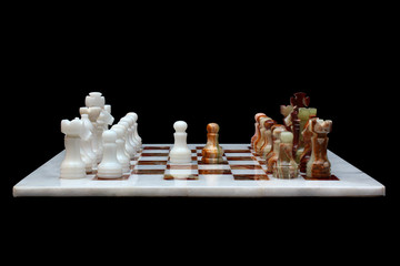 White marble and onyx stone chessboard with pieces, isolated on black background