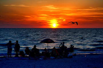 PASS-A-GRILLE BEACH, FLORIDA Ð MAY 14, 2016:  A sunset party silhouetted against the colorful Florida sunset.
