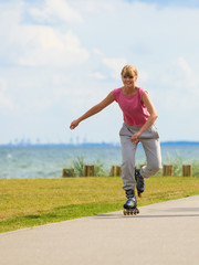 Girl skating alone on seafront.