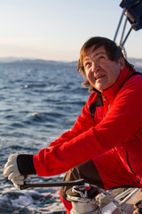 Fototapeta premium Skipper at the helm controls of a sailing yacht during sea boats race.