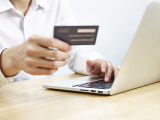 young man using credit card while shopping online