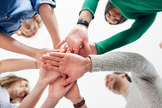 Cropped shot of a group of colleagues joining their hands together in agreement