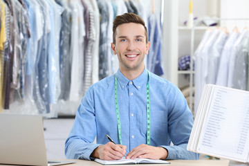 Male worker in dry-cleaning salon