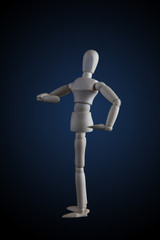 Wooden figurine flexing muscles in bodybuilder pose on dark background