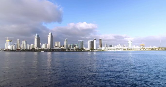 A wide, dramatic daytime establishing shot of the San Diego city skyline as seen from the bay.  	